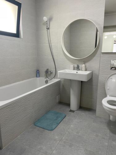 a bathroom with a tub and a sink and a mirror at App Town North Pipera 32 in Voluntari