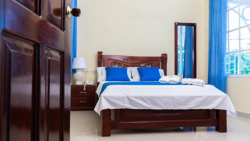 a bedroom with a bed with blue and white pillows at Hotel Arce Plaza in Valledupar
