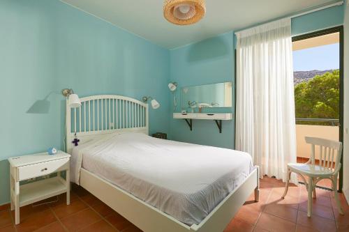 a bedroom with a bed and a bathroom with a sink at soft blue apartment near seaside in Porto Rafti