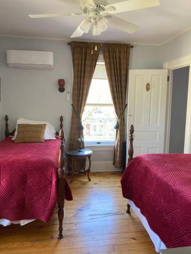a bedroom with two beds and a ceiling fan at Cooperstown Bed and Breakfast in Cooperstown