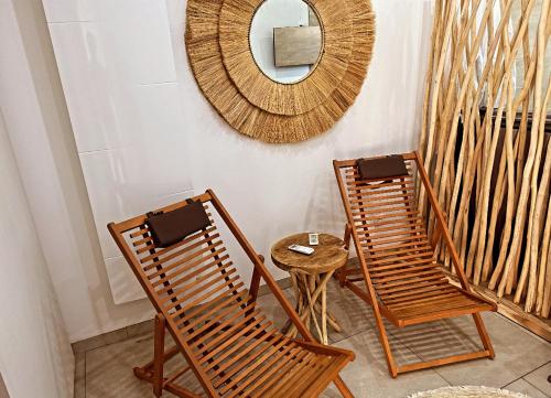 two rocking chairs and a mirror on a wall at Espace privé - Gîte & Spa in Méricourt