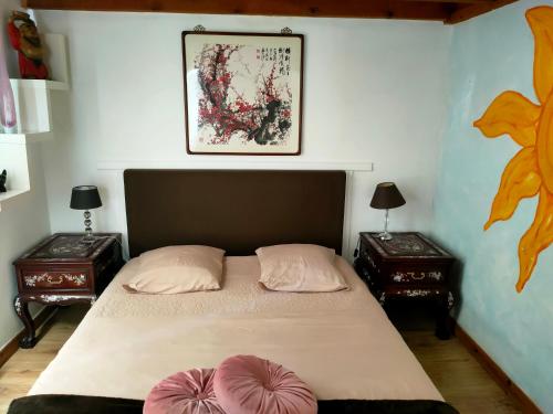 une chambre avec un grand lit avec deux tables de nuit dans l'établissement Un petit coin de campagne, à Beychac-et-Caillau