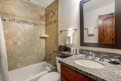 un bagno con lavandino, WC e specchio di Ski In, Ski Out 1 Bedroom Condo At The Eagle Bahn Gondola a Vail