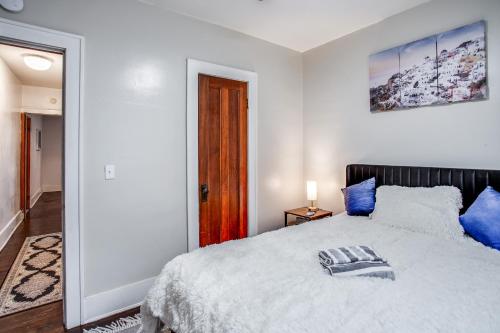 a white bedroom with a bed with blue pillows at Amazing 3 bedroom home Steps, Airport, UofR, RIT, Strong in Rochester
