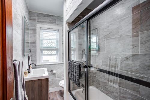 a bathroom with a shower and a tub and a sink at Amazing 3 bedroom home Steps, Airport, UofR, RIT, Strong in Rochester