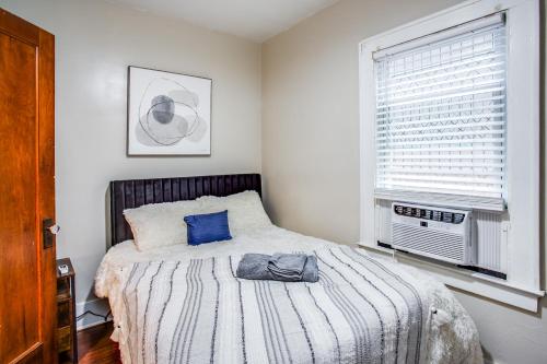 a bedroom with a bed with blue pillows and a window at Amazing 3 bedroom home Steps, Airport, UofR, RIT, Strong in Rochester