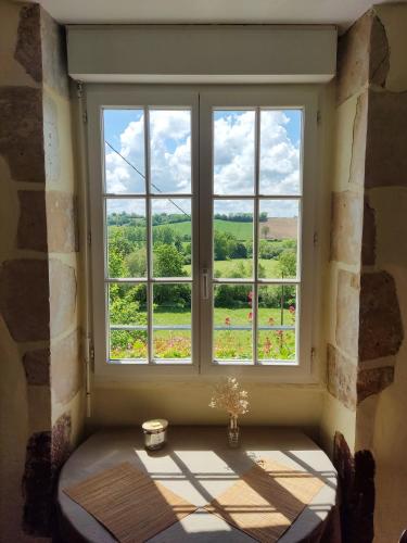une fenêtre avec vue sur un champ vert dans l'établissement Studio reposant au milieu de la campagne, à Montgaudry