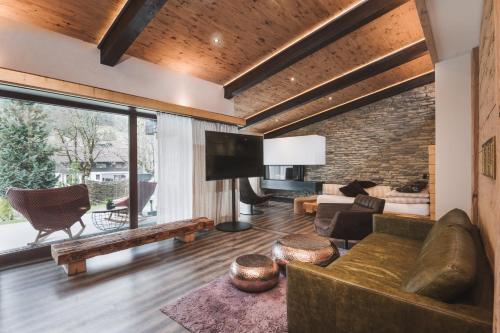 Una sala de estar con un sofá y un televisor. en Alpendomizil Zugspitze, en Lermoos