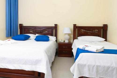 two beds sitting next to each other in a bedroom at Hotel Arce Plaza in Valledupar