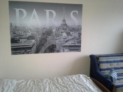 a picture of the eiffel tower on the wall of a bedroom at 1 kambario butas in Panevėžys