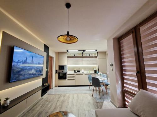 Una sala de estar con un televisor en la pared. en Delux Apart Vulchevi with Parking, en Burgas