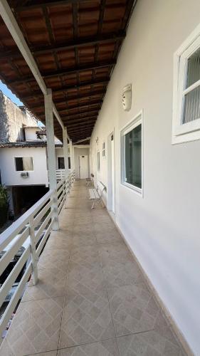 a porch of a white building with a wooden ceiling at GUEST HOUSE Floresta Mar in Angra dos Reis