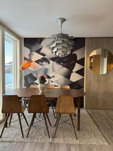 a dining room with a table and chairs and a mural at EnUtsiktBalsfjord in Storsteinnes