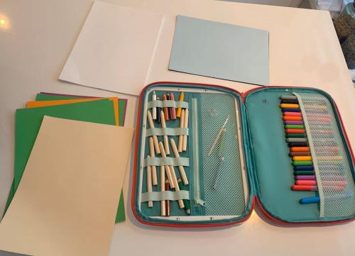 a suitcase full of pens and pencils on a table at EnUtsiktBalsfjord in Storsteinnes