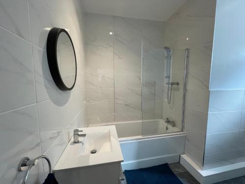 a bathroom with a tub and a sink and a mirror at Flat 2, 297 Gillott Road, B16 0RT in Birmingham