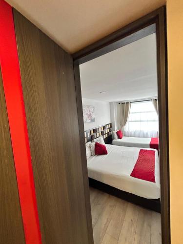 a hotel room with two beds and a window at AW Hotel Ariston in Bogotá