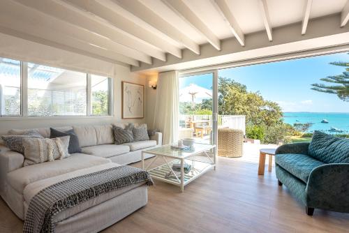 un salon avec un canapé et une table dans l'établissement Picnic Bay Vista - Be My Guest Waiheke, à Putaki Bay