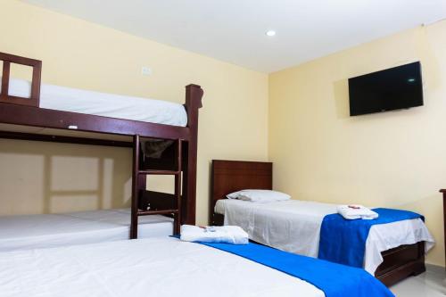 a bedroom with two bunk beds and a flat screen tv at Hotel Arce Plaza in Valledupar