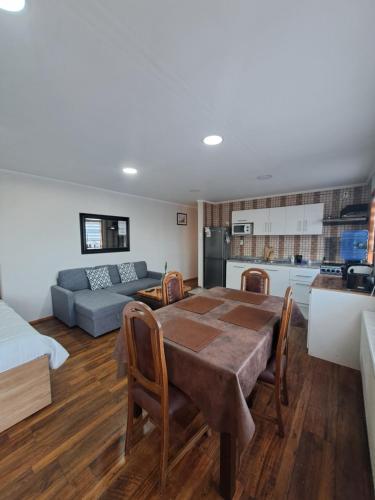 a kitchen and living room with a table and a couch at cabañas el rancho in Puerto Natales