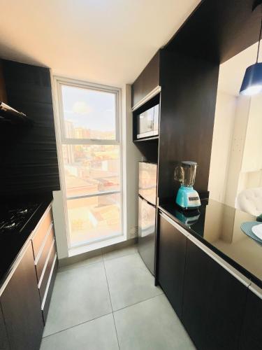 a kitchen with black cabinets and a window in it at Moderno Estudio en San Miguel in La Paz