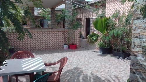 a patio with a table and chairs and plants at LaBelleVue - penthouse en Sipres 5, plage in Mbaw