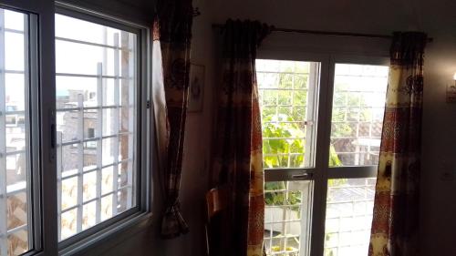 two windows with curtains in a room with a view at LaBelleVue - penthouse en Sipres 5, plage in Mbaw