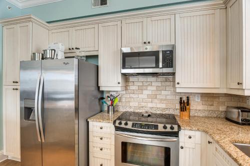 a kitchen with a stainless steel refrigerator and microwave at Breezy St Simons Hideaway with Waterfront Views! in Saint Simon Mills