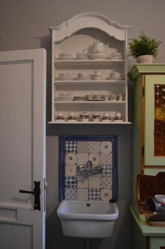 a bathroom with a sink and a toilet and shelves at B&B Al Golfo in Salerno