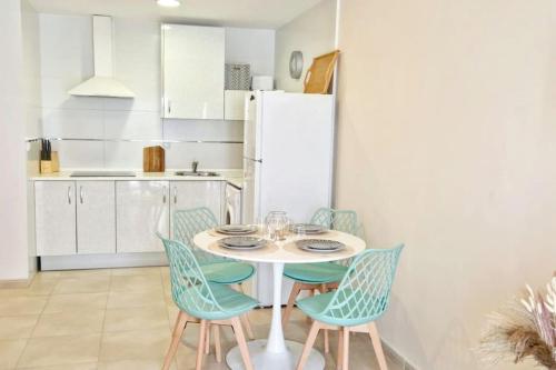 a kitchen with a table and chairs and a refrigerator at Dúplex Chiclana Centro con Terraza y Parking By Chiclana Dreams in Chiclana de la Frontera