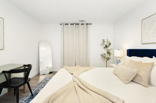 a white bedroom with a bed and a desk at Chic & Cozy Condo in Manhattan with Free Parking & WiFi in Manhattan