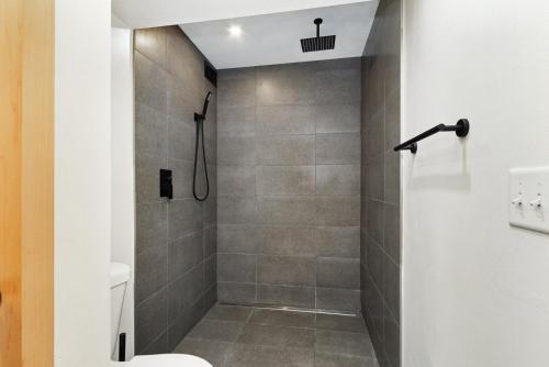 a bathroom with a shower with a toilet at Chic & Cozy Condo in Manhattan with Free Parking & WiFi in Manhattan