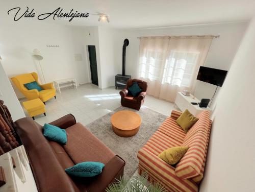 a living room with couches and chairs and a television at Vida Alentejana in Reguengos de Monsaraz