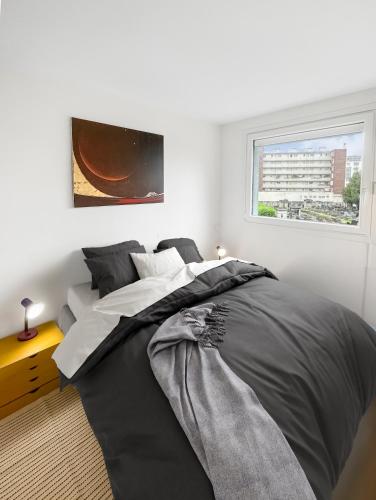 une chambre avec un grand lit avec une fenêtre dans l'établissement Confort et Style aux Portes de Paris, à Saint-Ouen