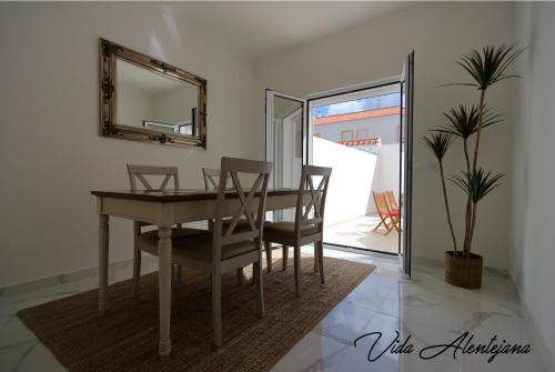 a dining room with a table and chairs and a mirror at Vida Alentejana in Reguengos de Monsaraz