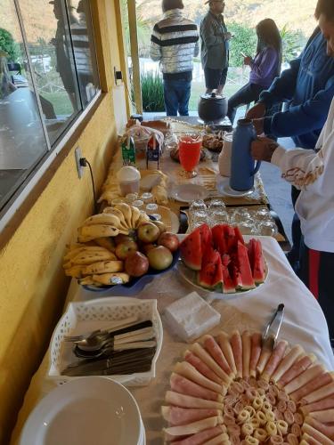 a table topped with plates of food and fruit at Pousada do Juninho in Capitólio