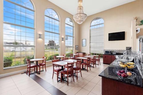 a restaurant with tables and chairs and windows at Best Western Airport Inn in Moline