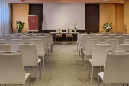 a room with rows of chairs and a podium at NH Collection Milano Touring in Milan