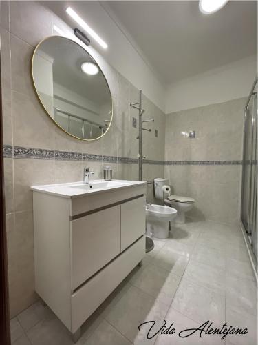 a bathroom with a sink and a mirror and a toilet at Vida Alentejana in Reguengos de Monsaraz