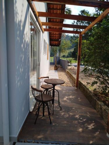 a patio with two chairs and a table on the side of a building at Suítes Garden in Pomerode