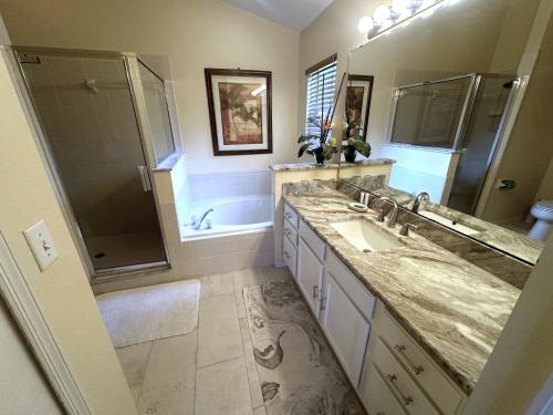 a bathroom with a sink and a shower and a tub at Upgraded Pool Villa Spa Southern Dunes in Haines City