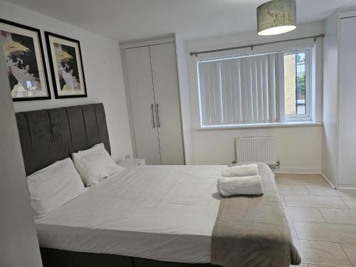 a bedroom with a large white bed with a window at Fabulous guest house in Dartford in Kent