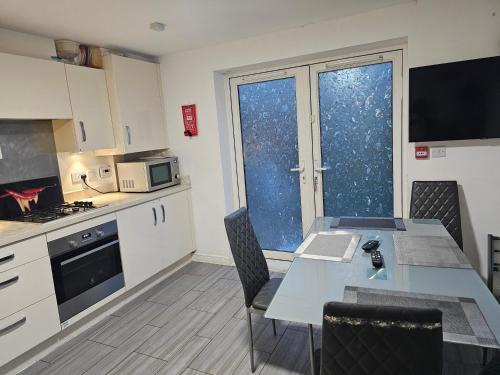 a kitchen with a table with chairs and a dining room at Fabulous guest house in Dartford in Kent