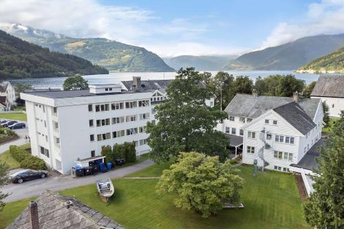 an aerial view of a large white building with a lake at Kinsarvik Fjordhotel, BW Signature Collection in Kinsarvik