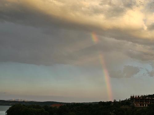 a rainbow in the sky over the water at Lake Dream 1 in Sretenovo