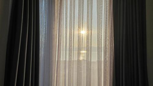 a window with the sun shining through the curtains at Lake Dream 1 in Sretenovo