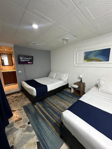 a hotel room with two beds and a tv at Way Maker sede 2 in Bogotá