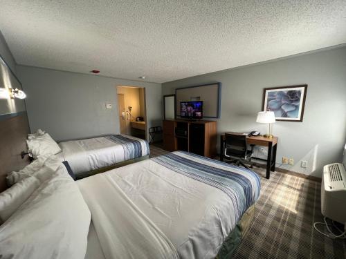 a hotel room with two beds and a desk at AmericInn by Wyndham Glendale Milwaukee in Glendale