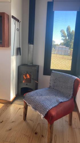 a living room with a chair and a fireplace at Casita Petra in Tandil