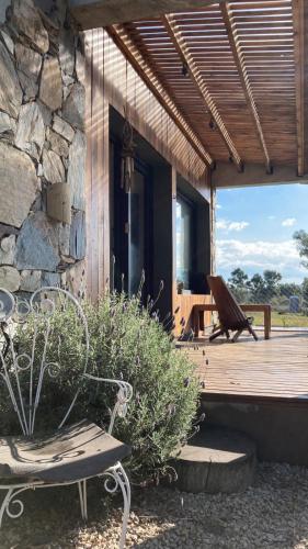 a wooden porch with a bench on a deck at Casita Petra in Tandil