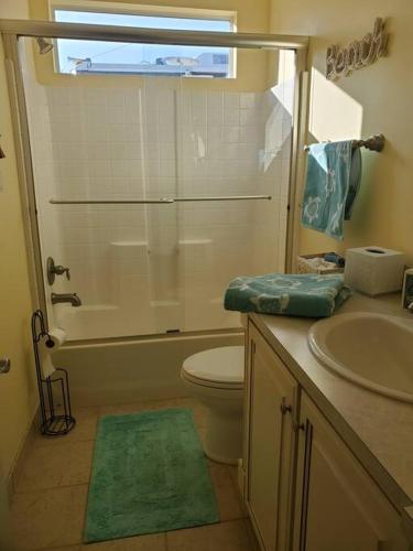 a bathroom with a shower and a toilet and a sink at Stylish 2 bedroom home Steps from private beach in Waveland